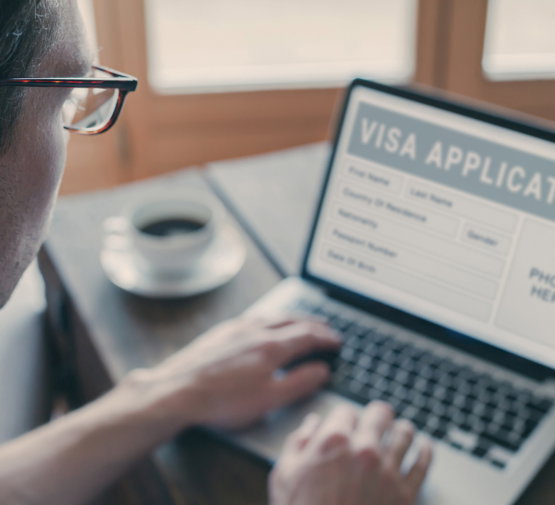 Online,Visa,Application,,Man,Filling,Form,For,Immigration,Or,Tourism Man on a laptop filling out Visa Application