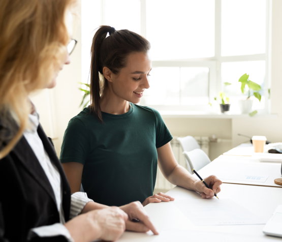 Mature,Business,Teacher,Supervising,Happy,Student,Writing,Notes.,Middle,Aged Woman signing documents for her attorney