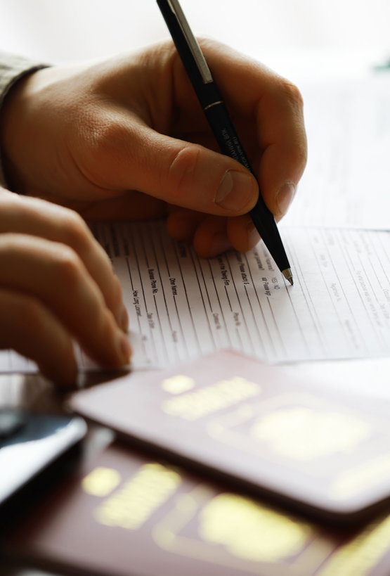 Filling,Out,Forms,For,International,Travel,With,Passports,,Papers,,And Close-up of man filling out passport forms