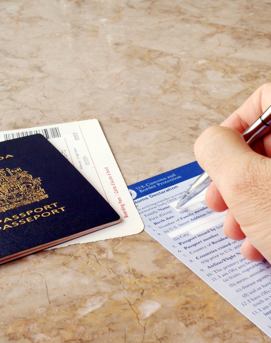 Man,Filling,Out,U.s.,Customs,And,Border,Form,With,Canadian Close-up of a man filling out a Customs form